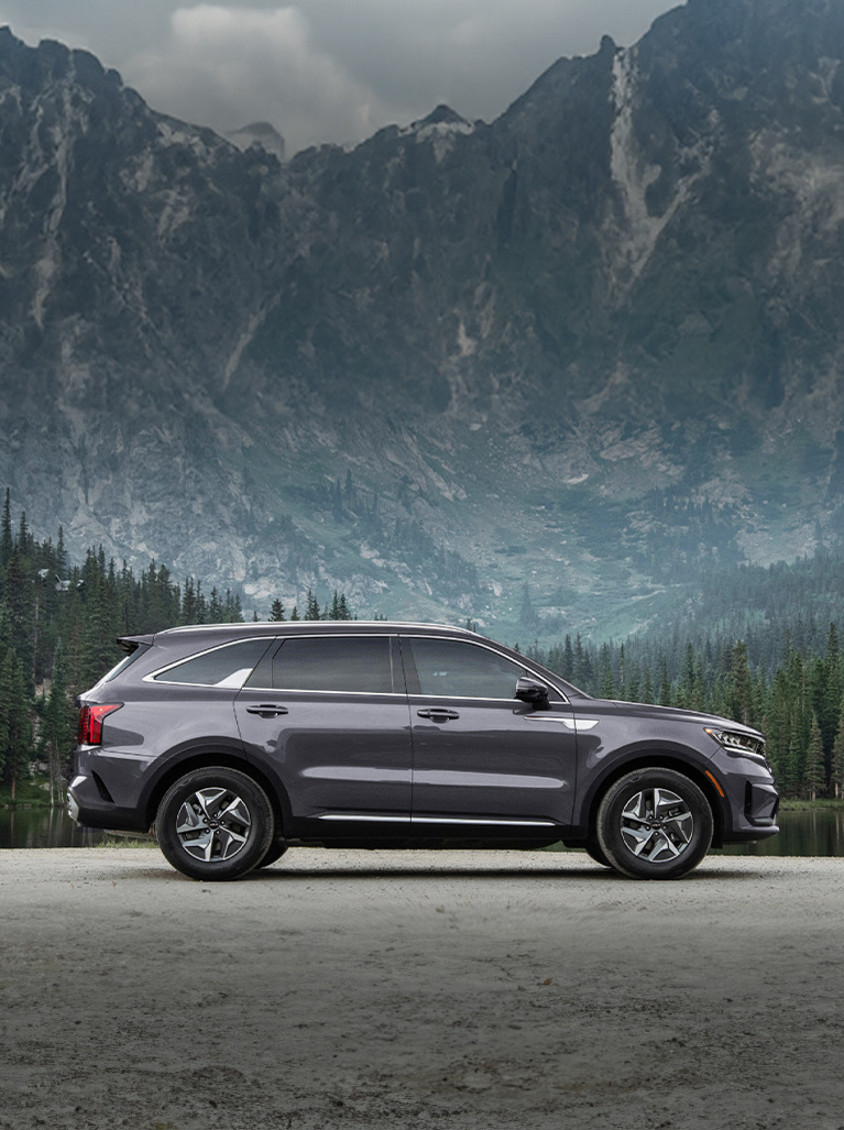 2024 Kia Sorento Hybrid, side view, parked in front of a lake in the mountains