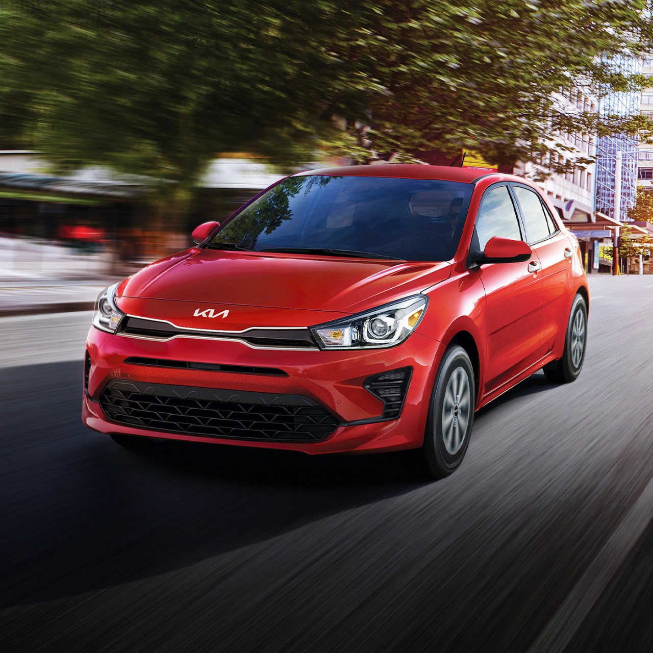 2023 Rio 5-Door in red, action shot front view driving down a city street