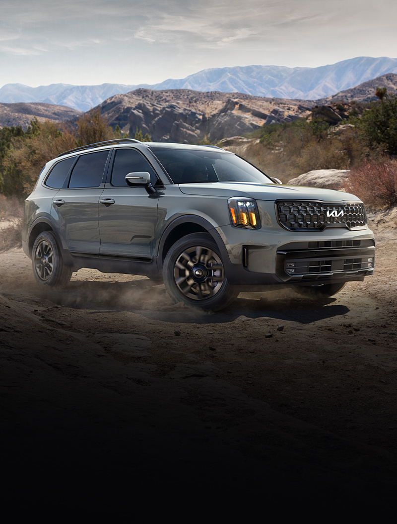 Vista de tres cuartos del Kia Telluride 2024 conduciendo por un sendero sin asfaltar